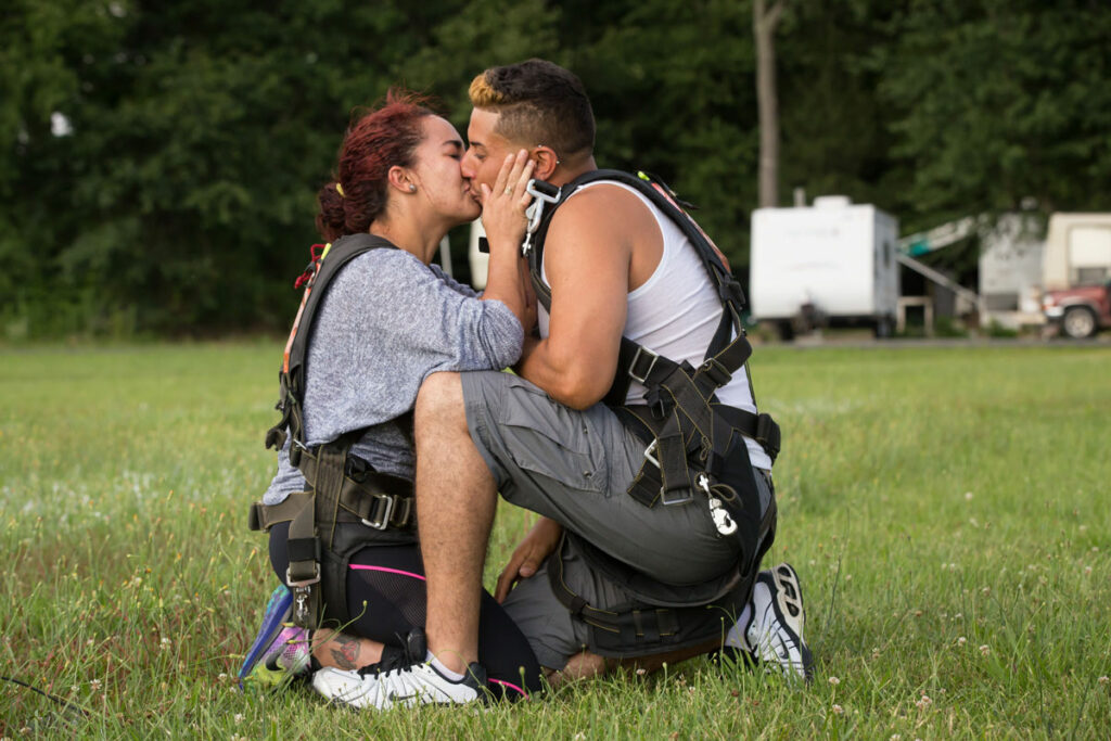 Skydivers kissing after marriage proposal.