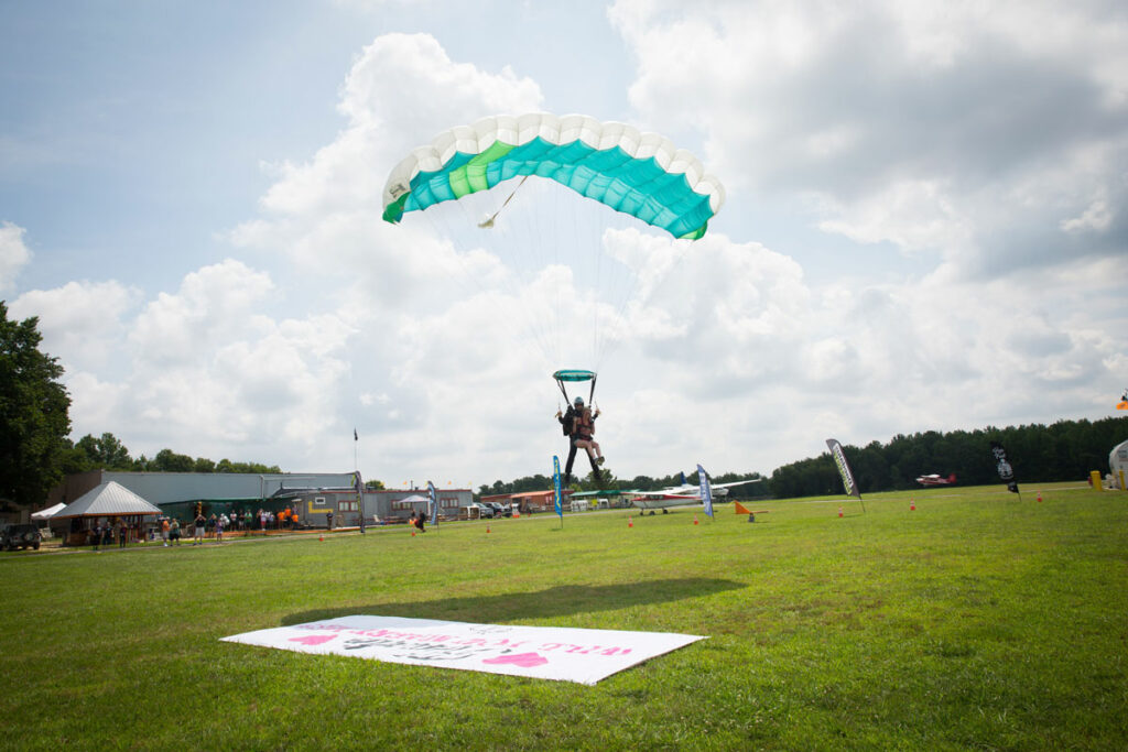 Skydiver landing on wedding proposal banner.